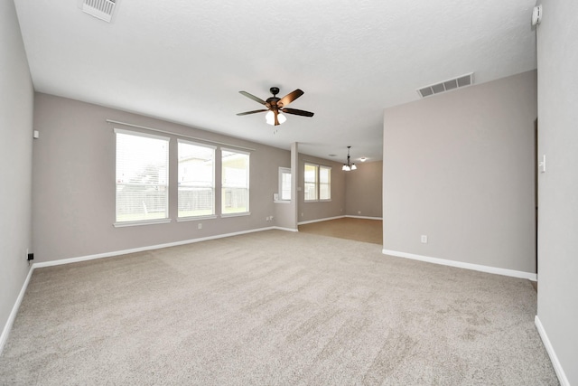 unfurnished room featuring light carpet, a textured ceiling, and ceiling fan