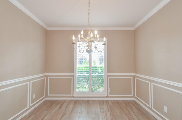 unfurnished room featuring an inviting chandelier, ornamental molding, and light hardwood / wood-style floors