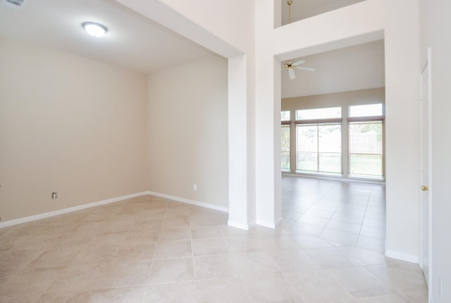 tiled spare room featuring ceiling fan