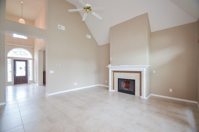 unfurnished living room featuring a tiled fireplace, light tile patterned flooring, high vaulted ceiling, and ceiling fan