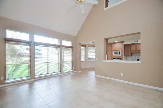 unfurnished living room with high vaulted ceiling, light tile patterned floors, and ceiling fan