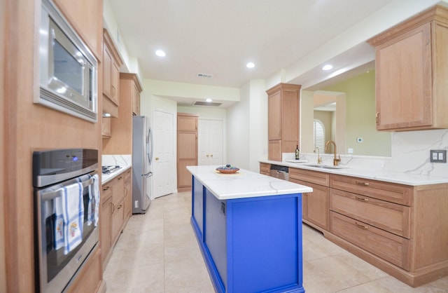 kitchen featuring a kitchen island, sink, decorative backsplash, kitchen peninsula, and stainless steel appliances