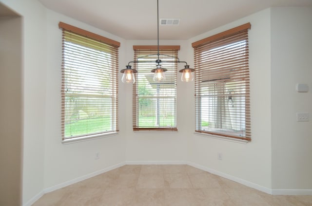 unfurnished dining area with light tile patterned flooring