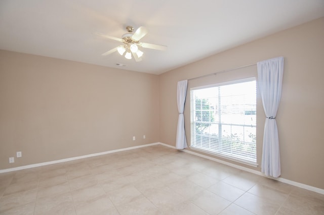 spare room featuring light tile patterned floors and ceiling fan