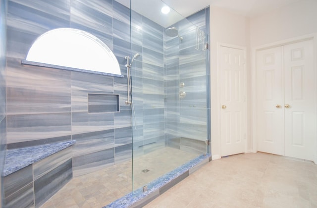 bathroom with tile patterned flooring and a shower with door