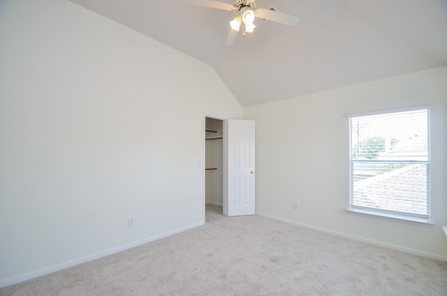 carpeted empty room with lofted ceiling and ceiling fan