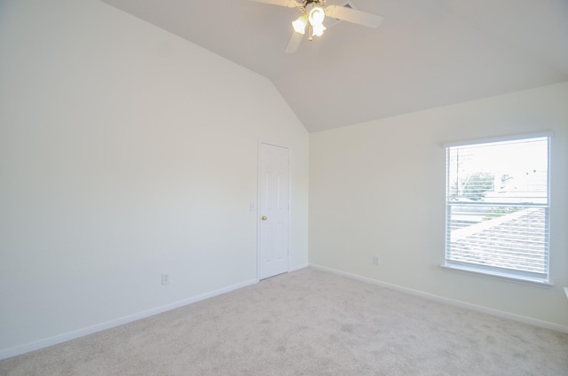 unfurnished room featuring light carpet, vaulted ceiling, and ceiling fan