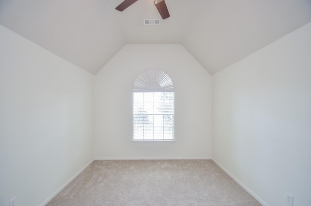 carpeted spare room featuring vaulted ceiling and ceiling fan