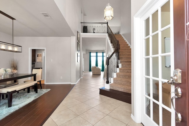 entrance foyer featuring a notable chandelier, light hardwood / wood-style flooring, and a high ceiling