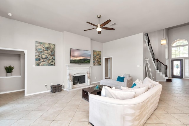 living room featuring lofted ceiling, ceiling fan, and light tile patterned floors