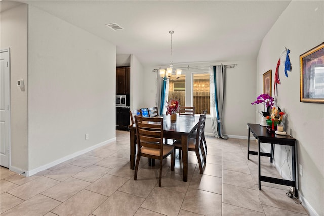 dining area featuring an inviting chandelier and light tile patterned floors