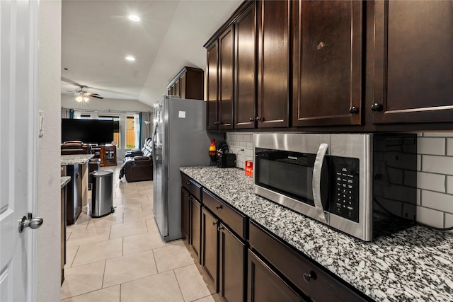 kitchen with ceiling fan, appliances with stainless steel finishes, backsplash, light stone counters, and light tile patterned flooring