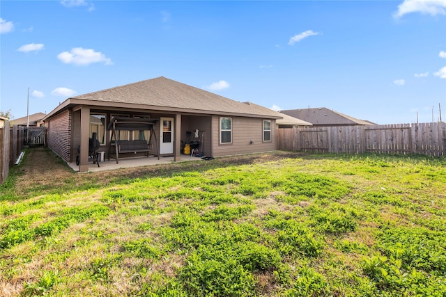 rear view of property featuring a patio and a yard