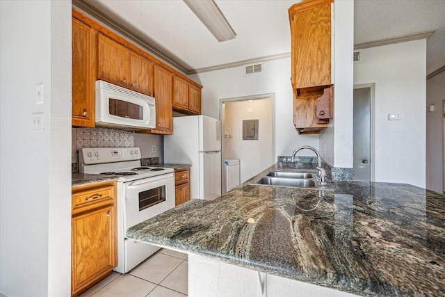 kitchen with sink, white appliances, ornamental molding, kitchen peninsula, and dark stone counters