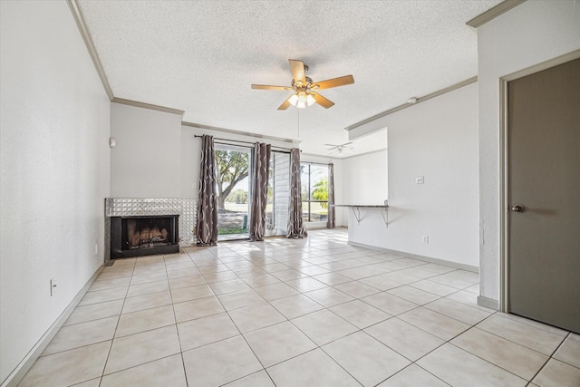 unfurnished living room featuring crown molding, a textured ceiling, light tile patterned floors, ceiling fan, and a tiled fireplace