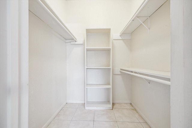 walk in closet with light tile patterned floors