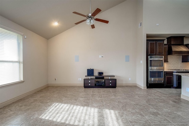 unfurnished living room featuring high vaulted ceiling and ceiling fan