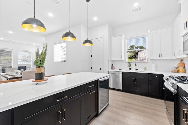 501 E 39th St, Houston, TX 77022 - kitchen featuring stainless steel appliances, dark cabinets, wine cooler, white cabinets, and recessed lighting