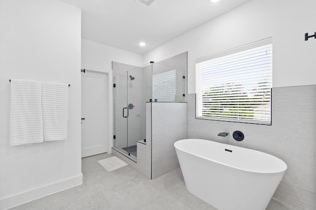 501 E 39th St, Houston, TX 77022 - full bathroom featuring a soaking tub, a shower stall, tile walls, and recessed lighting