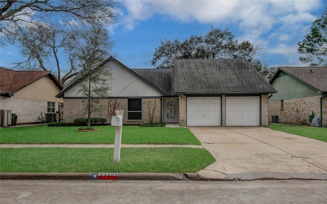 view of front of home featuring a front yard, concrete driveway, brick siding, and an attached garage