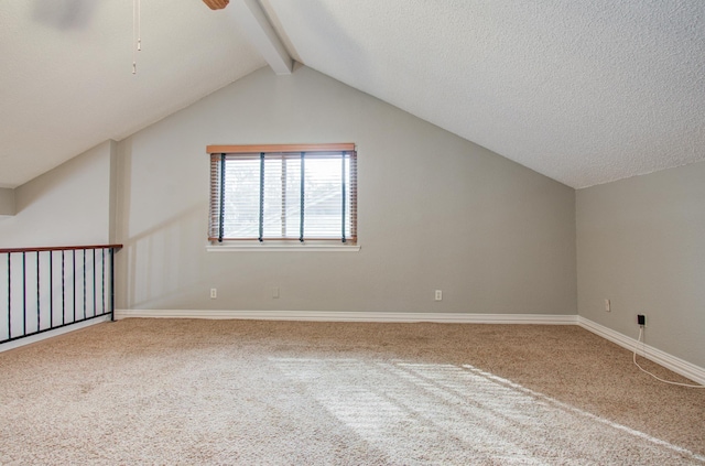 additional living space with a ceiling fan, carpet flooring, baseboards, and vaulted ceiling with beams