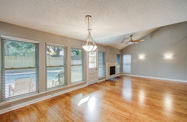 unfurnished living room featuring baseboards, light wood-style floors, and a healthy amount of sunlight