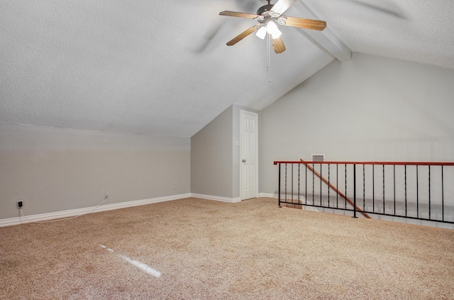 additional living space featuring a ceiling fan, a textured ceiling, lofted ceiling with beams, baseboards, and carpet flooring