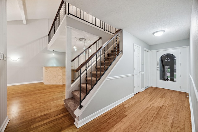 22403 Elsinore Dr, Katy, TX 77450 - entrance foyer featuring stairs, wood finished floors, a textured ceiling, and beamed ceiling