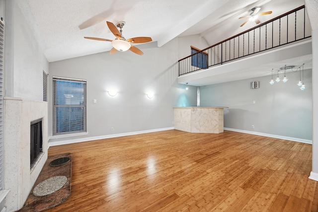 22403 Elsinore Dr, Katy, TX 77450 - unfurnished living room with a ceiling fan, high vaulted ceiling, wood finished floors, a fireplace, and stairs