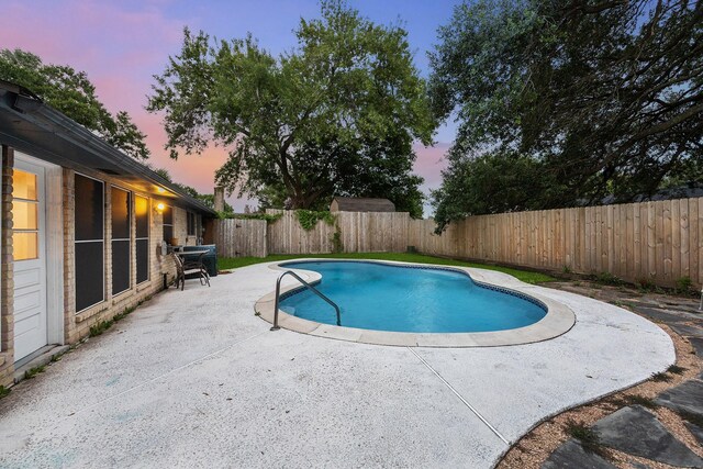 22403 Elsinore Dr, Katy, TX 77450 - pool at dusk featuring a patio area and a fenced backyard