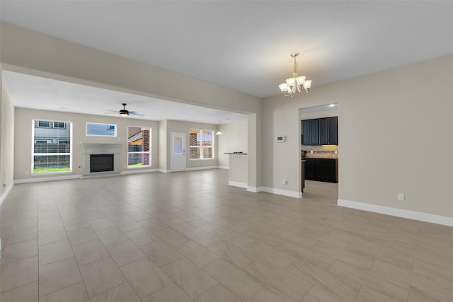 unfurnished living room with ceiling fan with notable chandelier