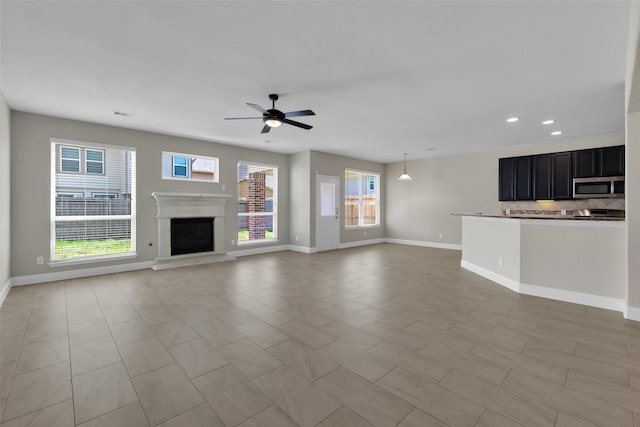 unfurnished living room with ceiling fan