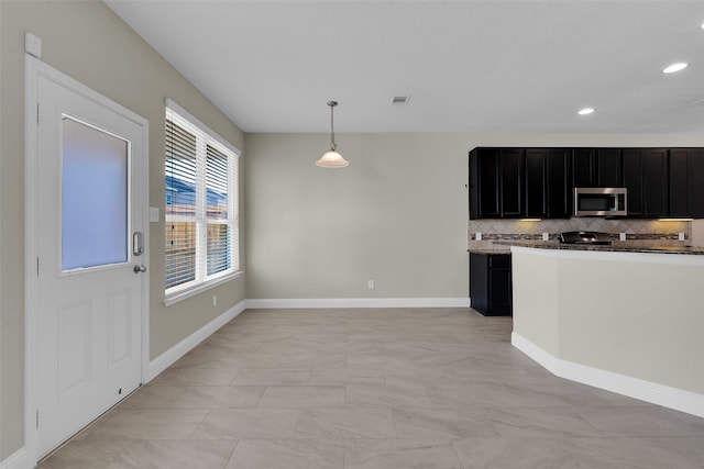 kitchen featuring hanging light fixtures, stove, and decorative backsplash