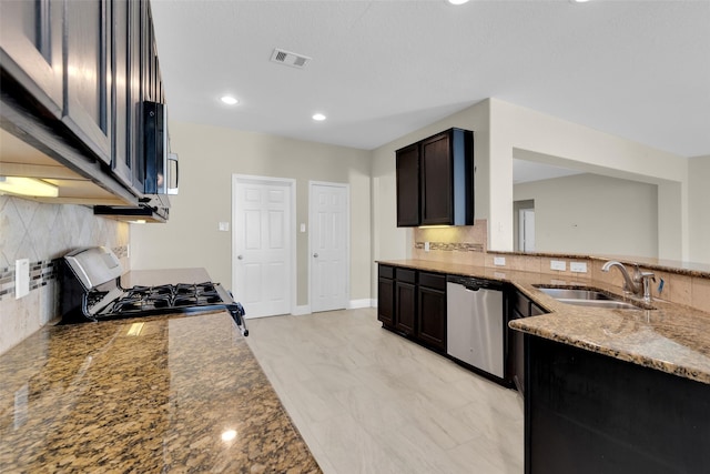 kitchen featuring tasteful backsplash, dark brown cabinetry, stainless steel appliances, light stone counters, and sink