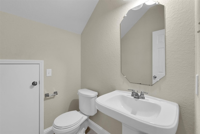 bathroom featuring lofted ceiling, sink, and toilet