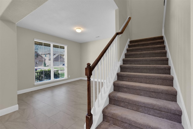 staircase featuring tile patterned flooring