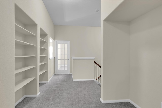 walk in closet featuring light carpet