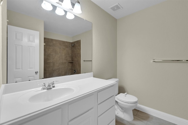 bathroom with vanity, a tile shower, and toilet