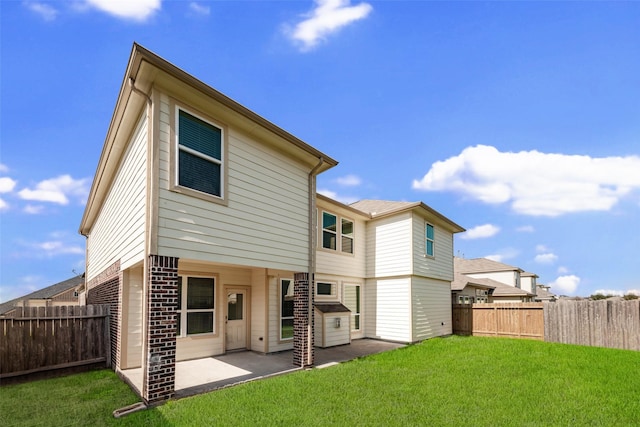 rear view of property with a yard and a patio area