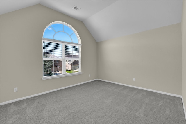 carpeted empty room featuring lofted ceiling