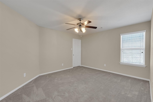 empty room featuring ceiling fan and light colored carpet