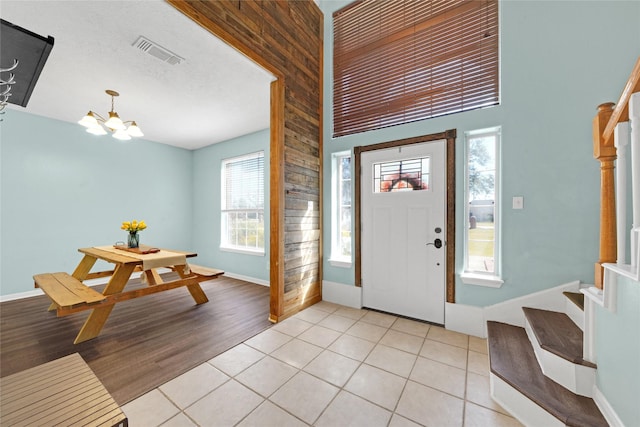 entrance foyer with a textured ceiling, a chandelier, and light hardwood / wood-style floors