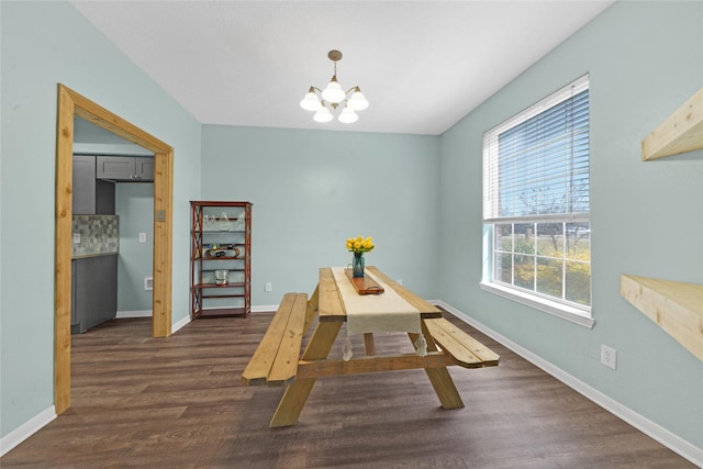 dining area with dark wood-type flooring and a notable chandelier