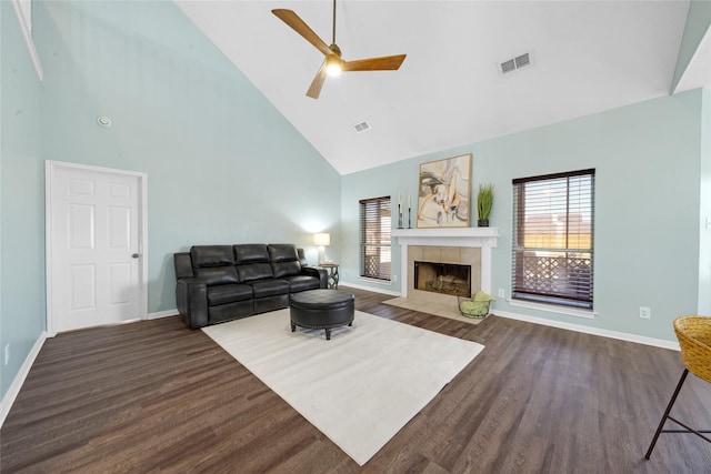 living room featuring ceiling fan, a fireplace, dark hardwood / wood-style flooring, and a wealth of natural light