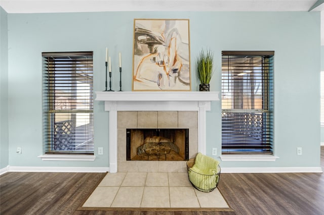 interior details featuring wood-type flooring and a tile fireplace