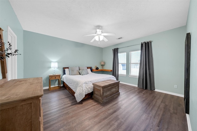 bedroom featuring dark wood-type flooring, a textured ceiling, and ceiling fan