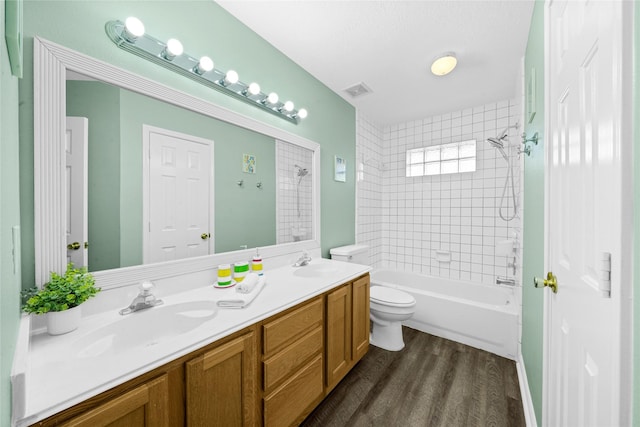 full bathroom featuring vanity, wood-type flooring, toilet, and tiled shower / bath