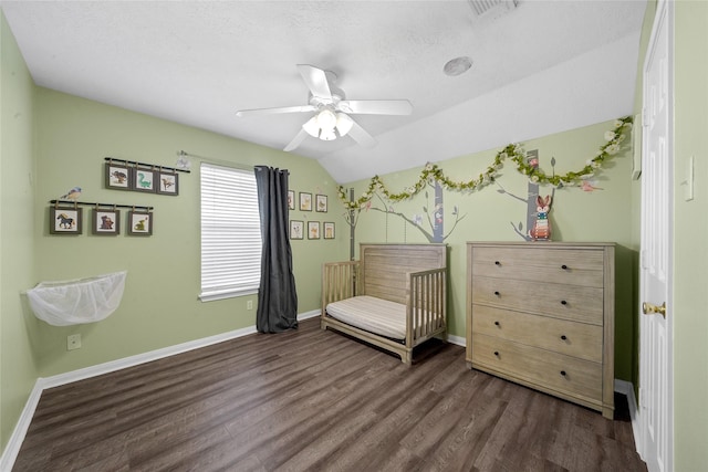 sitting room featuring dark wood-type flooring, vaulted ceiling, and ceiling fan