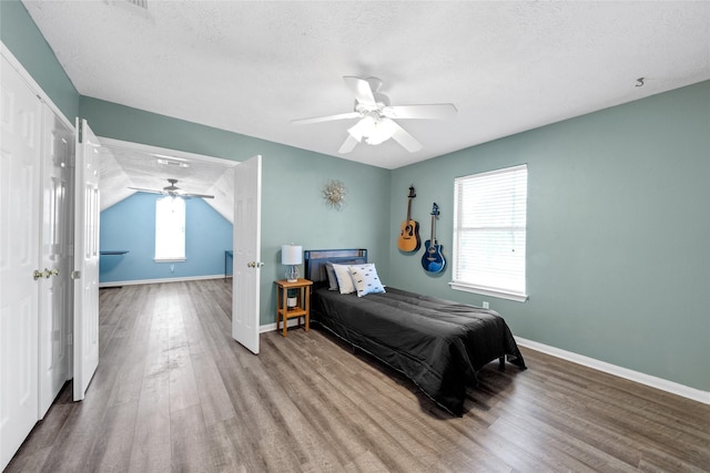 bedroom with lofted ceiling, ceiling fan, hardwood / wood-style flooring, and a textured ceiling