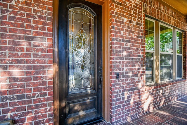 doorway to property with brick siding